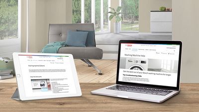 Laptop and tablet on a white table showing self-help articles and armchair in the background.